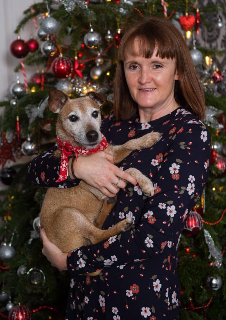 Pets Family Christmas - dog and owner by Christmas tree